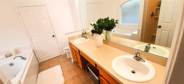 bathroom featuring tile patterned flooring, vanity, toilet, and a washtub