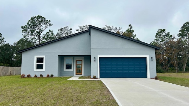 view of front of house with stucco siding, a front yard, fence, a garage, and driveway