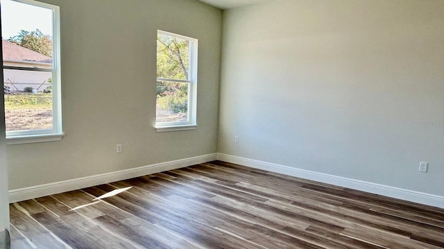 spare room with hardwood / wood-style floors and a healthy amount of sunlight