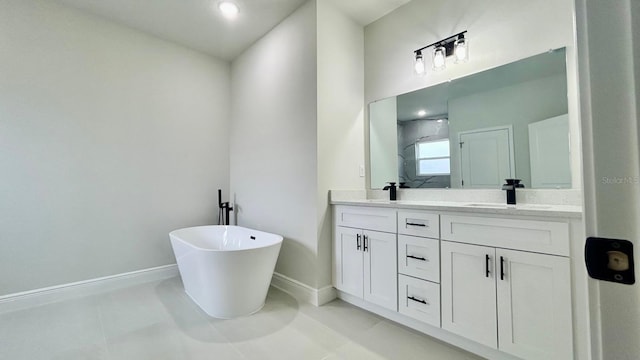 bathroom with double vanity, a stall shower, baseboards, tile patterned flooring, and a sink