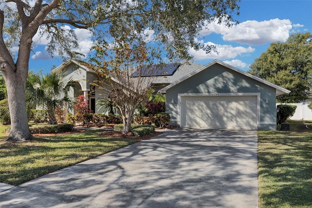 view of front of property featuring solar panels, a garage, and a front lawn