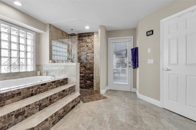 bathroom featuring a textured ceiling and separate shower and tub