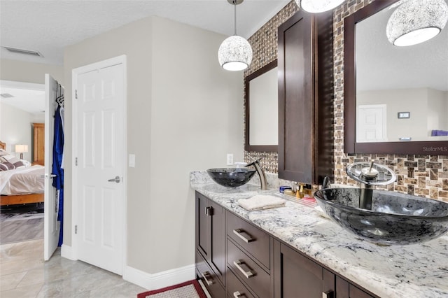 bathroom with tasteful backsplash, vanity, and a textured ceiling