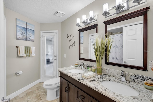 bathroom featuring vanity, a textured ceiling, tile patterned floors, and toilet