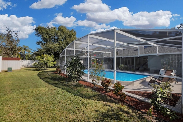 view of swimming pool with a yard and a lanai