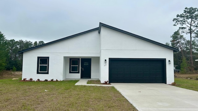 view of front of property with a front yard and a garage