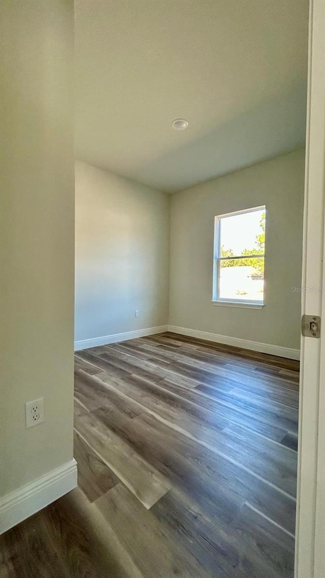 unfurnished room featuring dark wood-type flooring