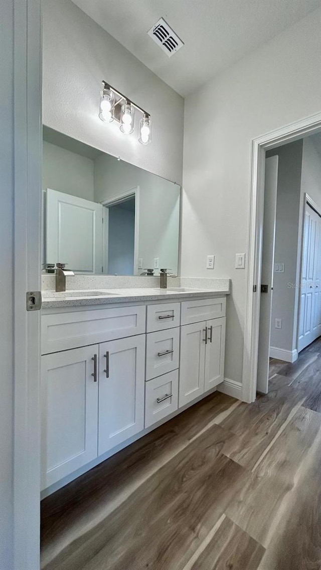559 Marion Oaks Blvd, Ocala, FL 34473 - bathroom with a sink, double vanity, visible vents, baseboards, and wood finished floors