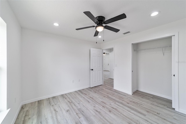 unfurnished bedroom featuring a closet, light hardwood / wood-style flooring, and ceiling fan