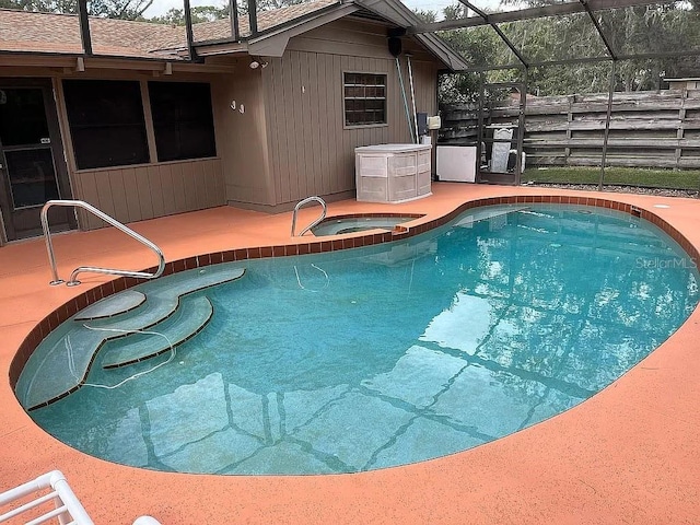 view of pool featuring a lanai, an in ground hot tub, and a patio