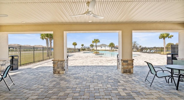 view of patio with ceiling fan and a community pool