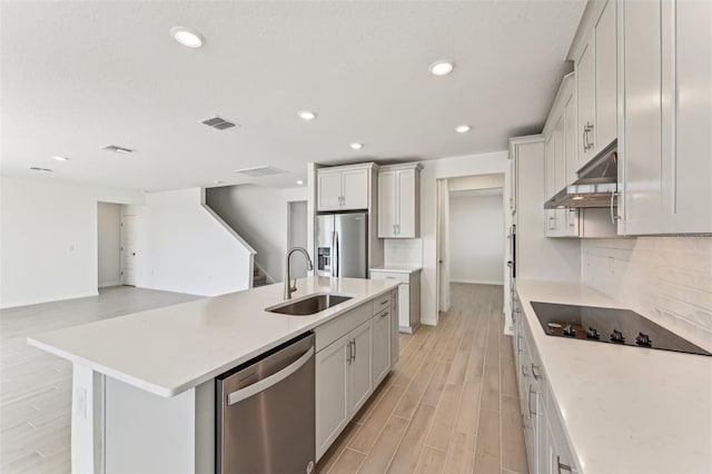 kitchen featuring light hardwood / wood-style flooring, a kitchen island with sink, white cabinetry, appliances with stainless steel finishes, and sink