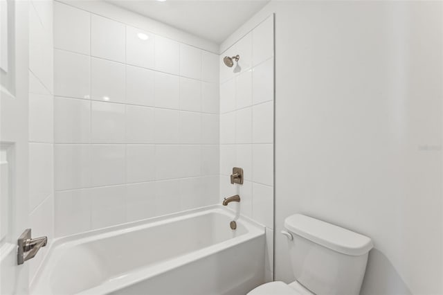 bathroom with toilet and tiled shower / bath combo