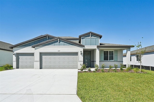 view of front of property featuring a front lawn, an attached garage, driveway, and stucco siding