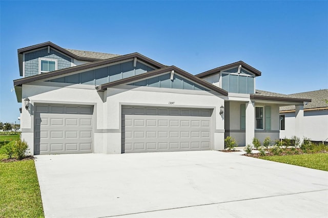 view of front of home with an attached garage, board and batten siding, driveway, and stucco siding