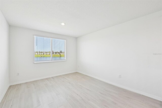 unfurnished room featuring light wood-style flooring and baseboards