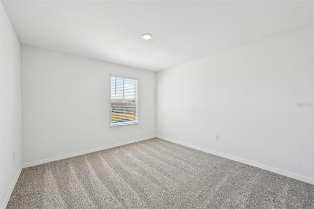 spare room with carpet flooring and baseboards