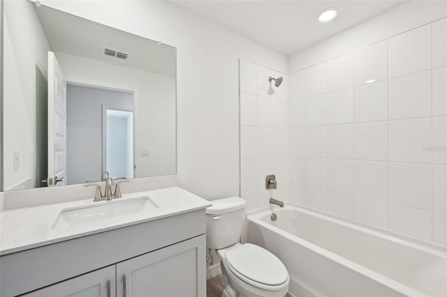 bathroom featuring visible vents, toilet, vanity, and shower / tub combination