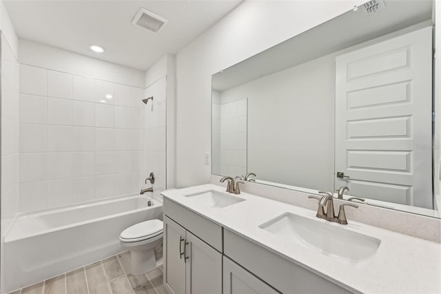 full bathroom with toilet, vanity, and tiled shower / bath combo