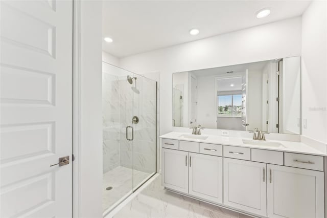 bathroom with a shower with shower door and vanity