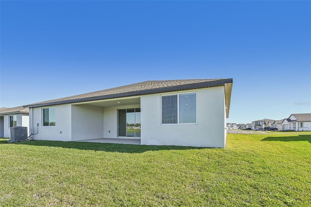 back of house featuring cooling unit, a patio area, and a lawn