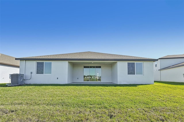 rear view of house featuring a lawn and central AC unit