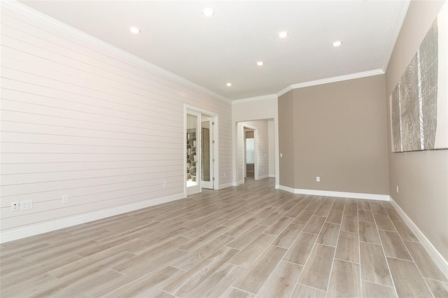 spare room featuring light wood-type flooring and ornamental molding