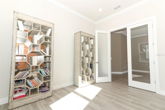 interior space featuring french doors, light wood-type flooring, and ornamental molding