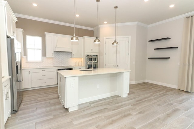 kitchen featuring a center island with sink, white cabinets, and pendant lighting