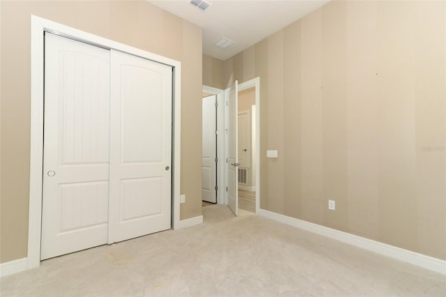 unfurnished bedroom featuring a closet and light colored carpet