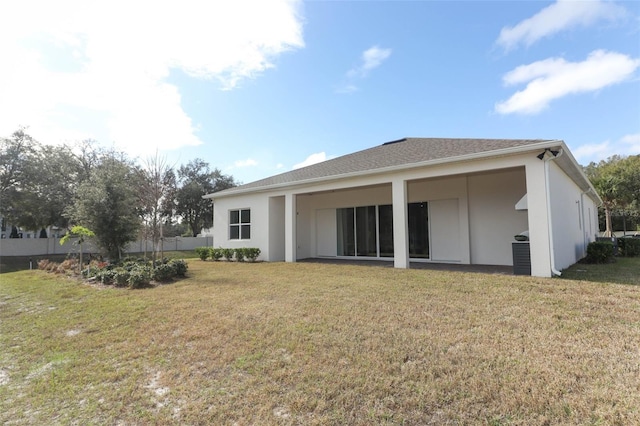 rear view of property with a lawn and cooling unit