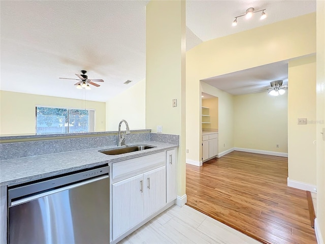 kitchen with ceiling fan, sink, stainless steel dishwasher, a textured ceiling, and light wood-type flooring