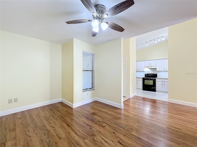 unfurnished living room featuring ceiling fan, track lighting, wood-type flooring, and a textured ceiling