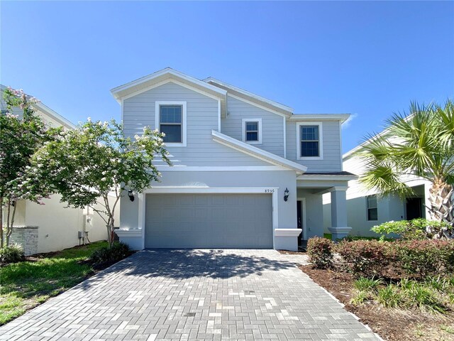 8956 Zurich Ln, Kissimmee, FL 34747 - traditional-style home featuring decorative driveway, stucco siding, and an attached garage