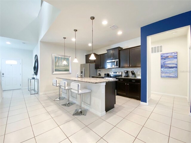 8956 Zurich Ln, Kissimmee, FL 34747 - kitchen featuring stainless steel appliances, a breakfast bar area, backsplash, light tile patterned flooring, and recessed lighting
