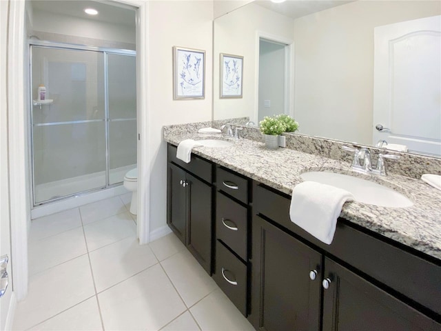 bathroom with tile patterned floors, vanity, toilet, and a shower with shower door