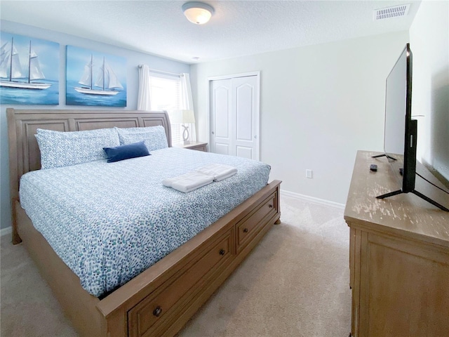 bedroom featuring light colored carpet, a closet, and baseboards