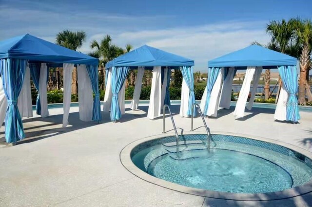 view of pool featuring a gazebo, a community hot tub, and a patio