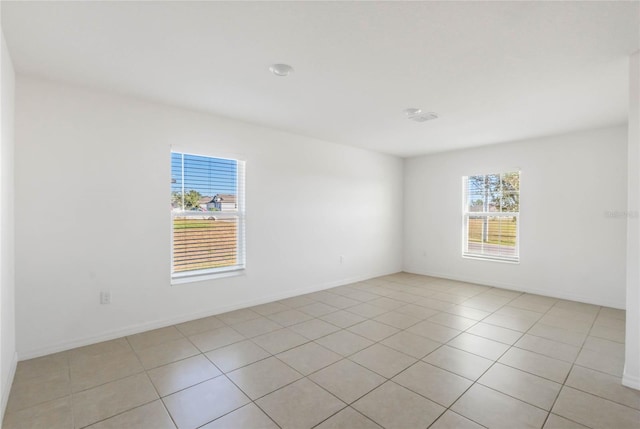 tiled spare room featuring a healthy amount of sunlight