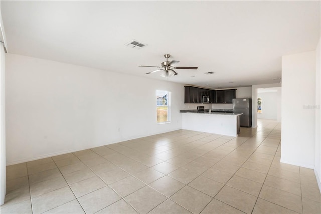 unfurnished living room featuring ceiling fan and light tile patterned floors