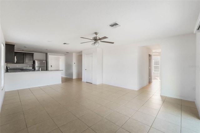 unfurnished living room featuring ceiling fan and light tile patterned flooring