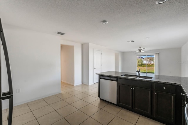 kitchen with ceiling fan, dark stone countertops, stainless steel dishwasher, sink, and light tile patterned floors