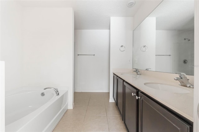 bathroom with vanity, tile patterned floors, a washtub, and a textured ceiling