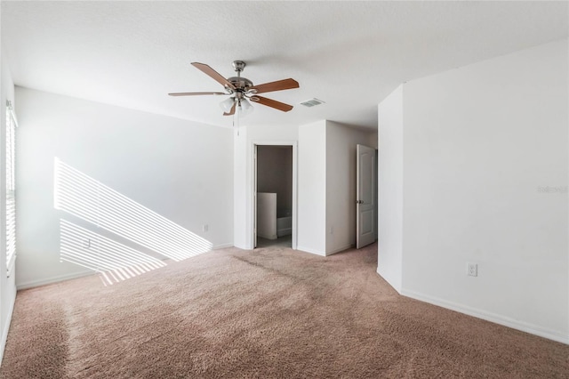 carpeted spare room featuring ceiling fan