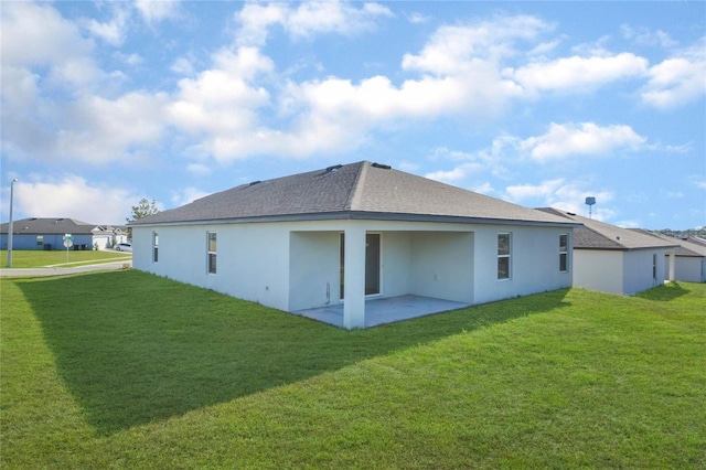 back of property with a lawn and a patio