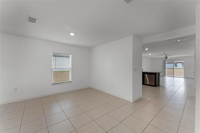 tiled empty room featuring ceiling fan