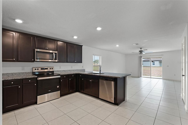 kitchen with sink, appliances with stainless steel finishes, kitchen peninsula, and a healthy amount of sunlight