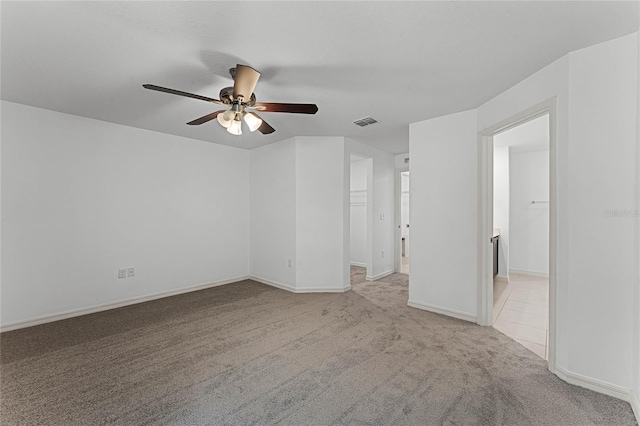 carpeted spare room featuring ceiling fan