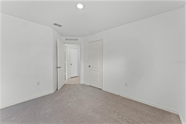 unfurnished room featuring light colored carpet