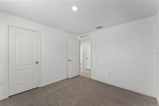 carpeted spare room featuring a textured ceiling